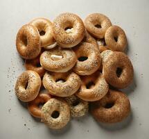 AI generated Tasty bagels with sesame seeds on light background, top view photo