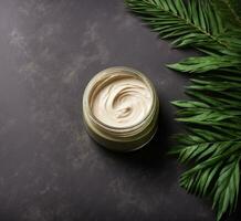 AI generated Jar of cosmetic cream and palm leaves on a dark background, top view photo