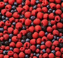 AI generated Raspberries and blueberries on a brown background. Top view. photo