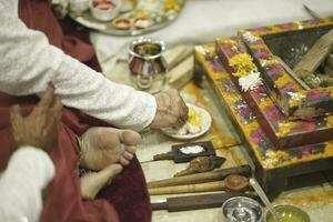 Indian wedding and pre wedding pooja ritual items and hands close up photo