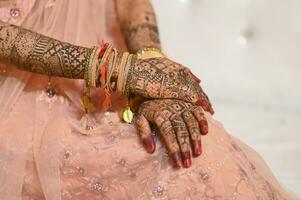 Indian bride hand with mehndi design and jewellery photo
