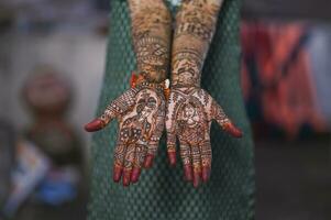 un hermosa obra de arte alheña en el mano de un indio novia con herbario heena en mojado condición foto