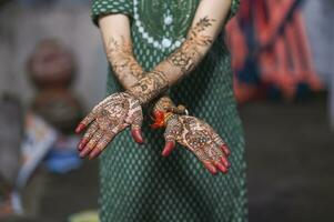 A Beautiful artwork henna on the hand of an Indian bride with herbal heena in wet condition photo