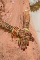 Indian bride hand with mehndi design and jewellery photo