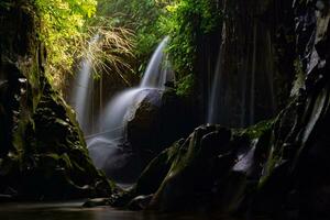 Visit the charm of Indonesia with the Lorong Watu waterfall, North Bengkulu. A narrow alley lined with stone walls, the morning light shines on the waterfall photo