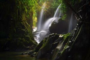 Visit the charm of Indonesia with the Lorong Watu waterfall, North Bengkulu. A narrow alley lined with stone walls, the morning light shines on the waterfall photo