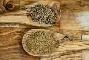 caraway seeds Carum carvi on olive wood photo