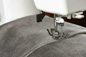 Modern sewing machine and gray fabric. Sewing process, handmade, hobby, DIY, business, repair photo