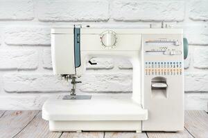 máquina de coser moderna sobre la mesa en el taller de sastre foto