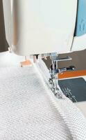 sewing machine. the process of sewing a decorative cord of white fabric. photo