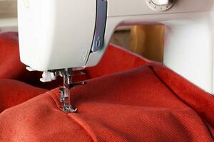 Modern sewing machine and red fabric photo
