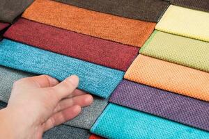 Woman hand chooses samples of colored tissue photo