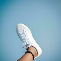 AI generated anonymous leg putting on white sneakers isolated on blue background. photo