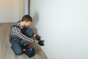 Electrician installs decorative frame on electric and TV sockets photo