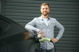 un hombre cargos un eléctrico coche foto