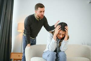 Irritated husband is shouting at his wife with violence. Woman is covering her face with fear photo