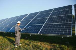 Indian handyman cleaning solar panels form dust and dirt photo