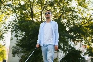 Blind man. Visually impaired man with walking stick, photo