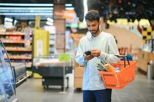 portrait of indian male in grocery with positive attitude photo