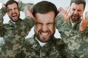 doble exposición de ansioso soldado en camuflaje uniforme gritando mientras sufrimiento desde ptsd aislado en gris foto