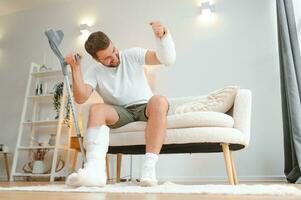 Happy man recovery from accident fracture broken bone injury with leg and arm. Social security and health insurance concept photo