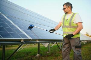 A handyman cleaning solar panels photo