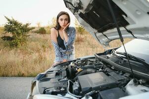 Sad woman depressed not knowing what to do with broken car photo