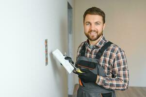 Electrician installs decorative frame on electric and TV sockets photo