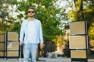 Blind man. Visually impaired man with walking stick, photo