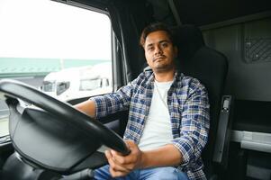 Portrait of a young handsome Indian truck driver. The concept of logistics and freight transportation. photo