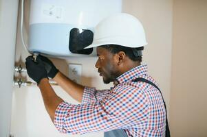 Professional engineer installing a natural gas boiler at home, he is checking the pipes photo