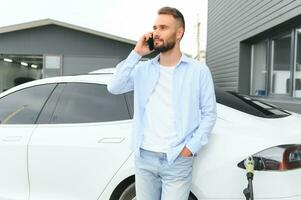 un hombre cargos un eléctrico coche foto