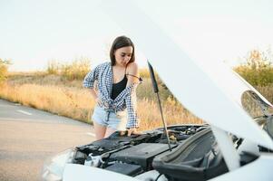 triste mujer Deprimido no conocimiento qué a hacer con roto coche foto