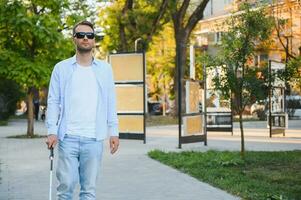 Blind man. Visually impaired man with walking stick, photo