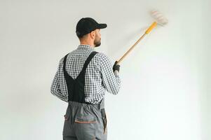 Young worker painting wall in room. photo