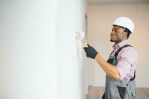 African-American painter doing repair in room photo