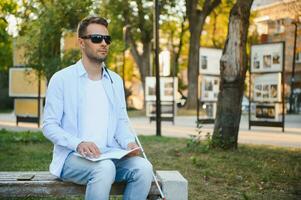 Blinded man reading by touching braille book photo