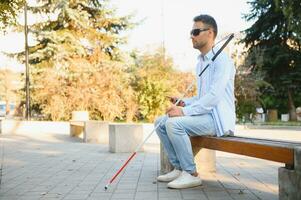 Blind man. Visually impaired man with walking stick, photo