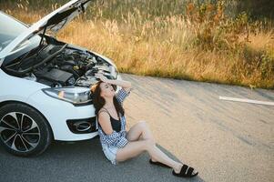 Sad woman depressed not knowing what to do with broken car photo