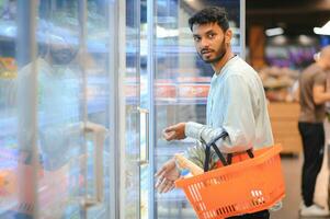 portrait of indian male in grocery with positive attitude photo