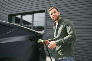 a man charges an electric car photo