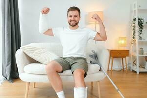 Happy man recovery from accident fracture broken bone injury with leg and arm. Social security and health insurance concept photo