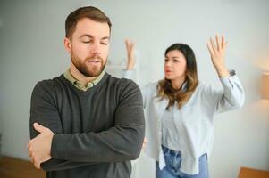 Abusive wife arguing husband, jealous distrustful dominant woman shouting at sad man photo
