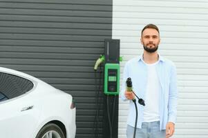 Man standing by his electric car photo