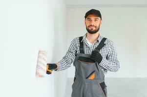 joven trabajador haciendo reparar en habitación. foto