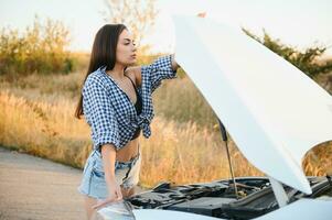 Beautiful sexy woman near a broken car. Confused woman does not know what to do photo