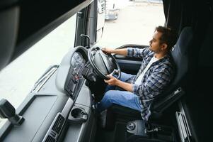 Portrait of a young handsome Indian truck driver. The concept of logistics and freight transportation. photo