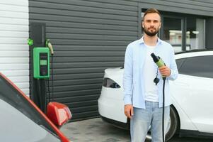 un hombre cargos un eléctrico coche foto