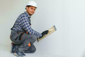 An Indian worker works in an empty apartment. A man in a uniform makes repairs inside the building photo