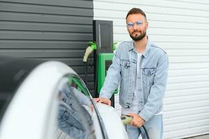 un hombre cargos un eléctrico coche foto